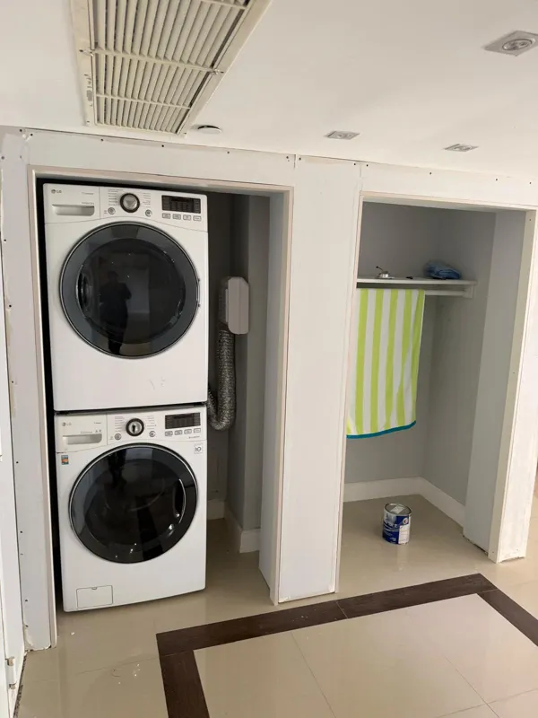 Laundry closet with stacked washer and dryer behind flush doors